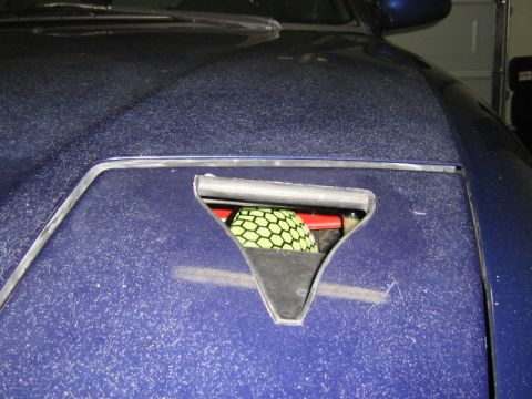 1995 Ford Probe - Close-up of a blue car's hood vent, revealing a green honeycomb air filter inside.