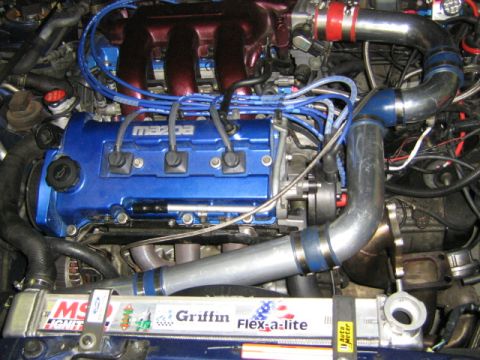 1995 Ford Probe - Close-up of a modified Mazda engine, turbo components and an aftermarket radiator.