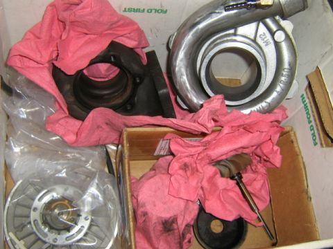1995 Ford Probe - Turbocharger components, including housings and a compressor wheel, are shown wrapped in pink rags inside a box.