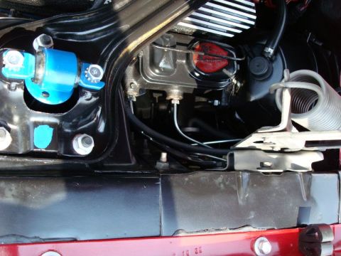 1968 Shelby GT500 - Close-up view of shock tower nuts and brake master cylinder in a vehicle's engine bay.