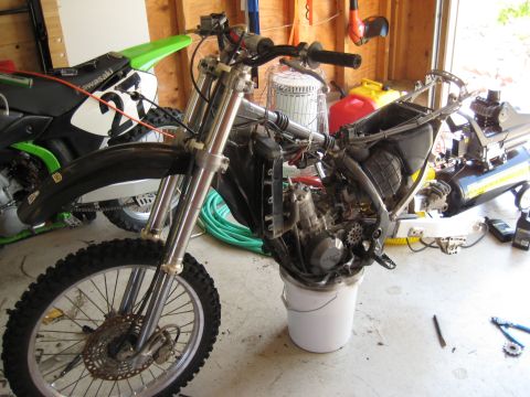 1993 Suzuki RMX250 - Motorcycle frame undergoing work, with a second motorcycle in the background.
