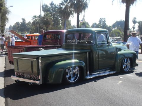 1990 Ford Bronco - A highly customized 1956 Ford F-100 pickup truck is shown from a three-quarter front view, with another truck visible behind it.