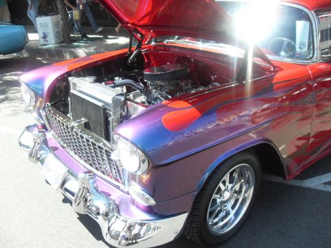 1990 Ford Bronco - A custom hot rod with a two-tone paint job and flame graphics is displayed with its hood open.
