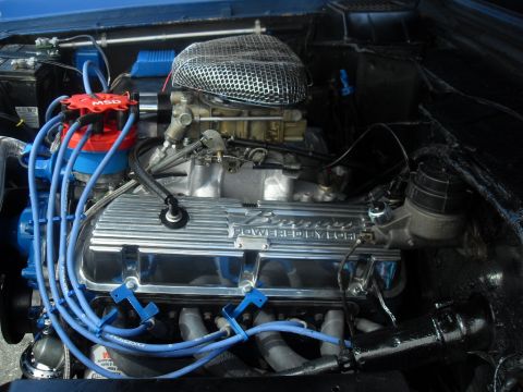 1990 Ford Bronco - Close-up of a "Bronco POWERED BY FORD" engine, blue spark plug wires and a chrome air filter housing.
