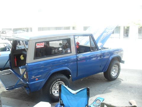 1990 Ford Bronco - Blue Ford Bronco with hood open and tailgate down. MSD Ignition sticker visible on the rear window.