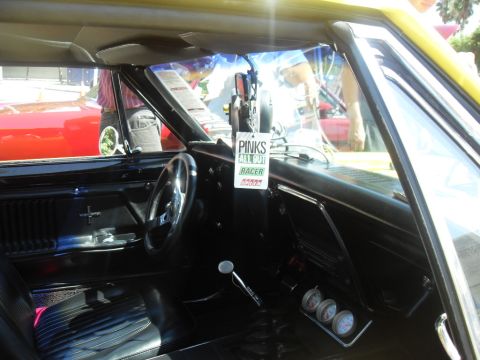 1990 Ford Bronco - Interior of a classic muscle car, possibly a 1967 Camaro, with a racing sign and gauges visible.