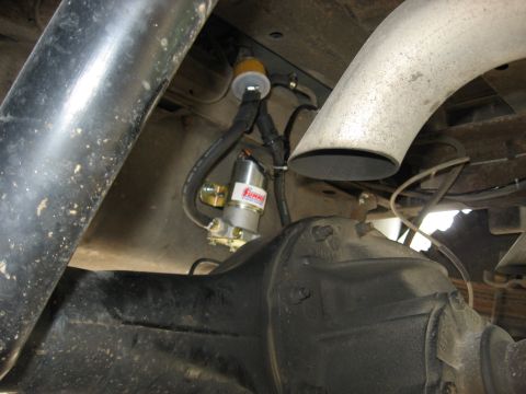1979 Ford Bronco - Undercarriage view of a vehicle's fuel pump and exhaust pipe, with visible SuperMotors branding.