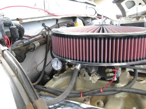 1979 Ford Bronco - Close-up of an engine bay an aftermarket air filter and a small gauge attached to the carburetor.