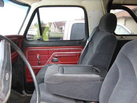 1979 Ford Bronco - Interior view of a 1979 Ford Bronco with red door panels and grey seats.