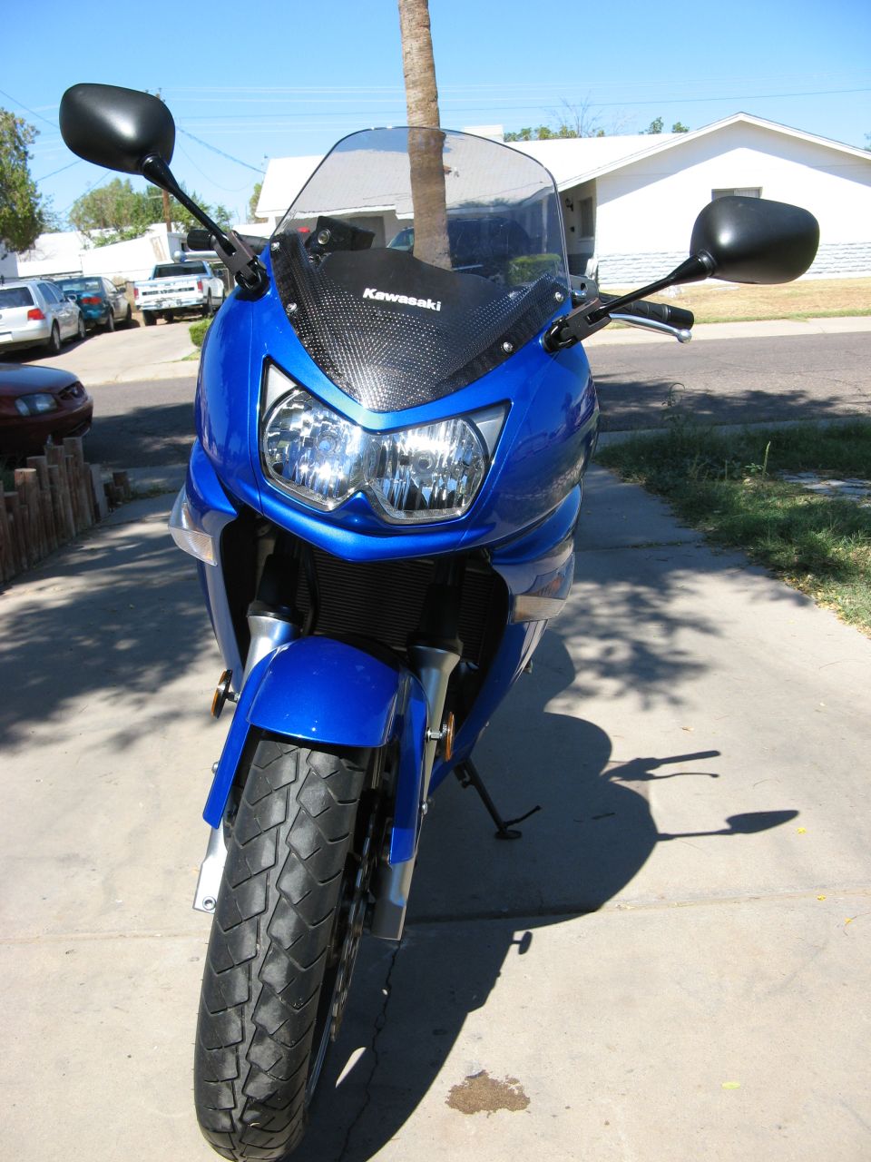 Blue Kawasaki sportbike front view with twin headlights and smoked windscreen