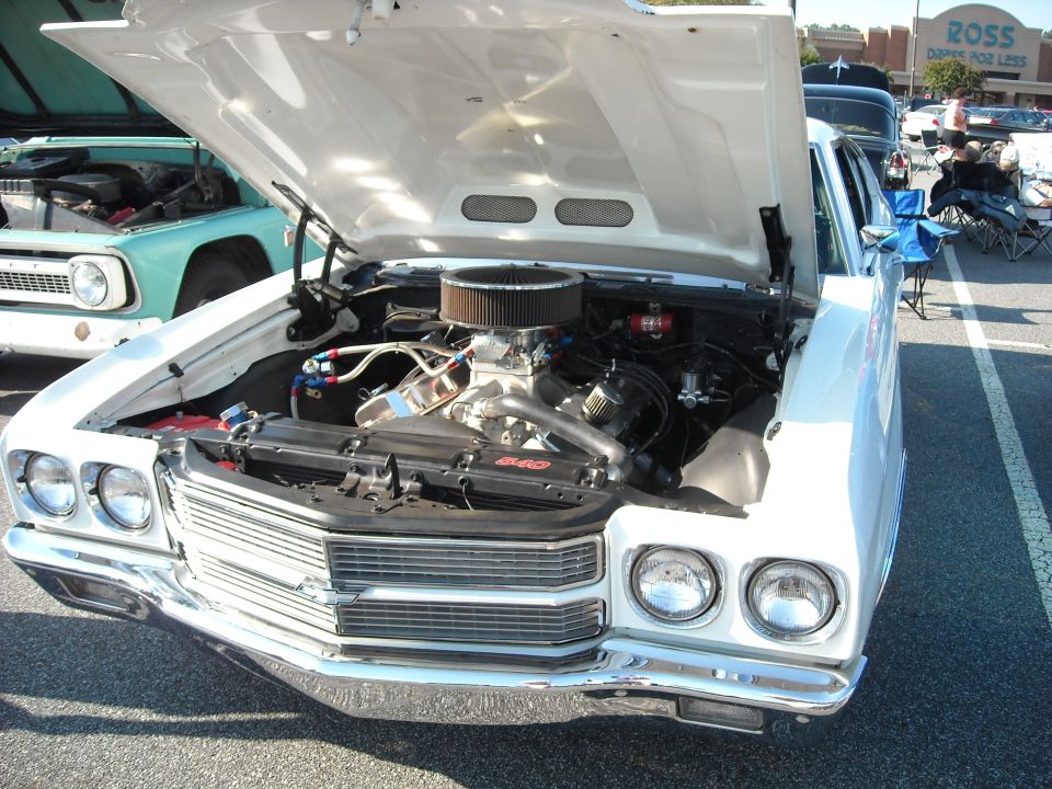 White 1970 Chevrolet Chevelle front end with hood open, revealing a V8 engine