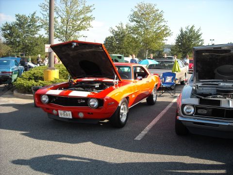 1979 Ford F-150 - Two classic Camaros are displayed at an outdoor event, with their hoods open to show the engines.