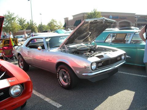 1979 Ford F-150 - A silver 1967 Chevrolet Camaro Z/28 is displayed with its hood open at a car show.