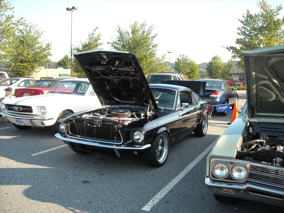 Black 1967-68 Ford Mustang fastback with hood up at a car show