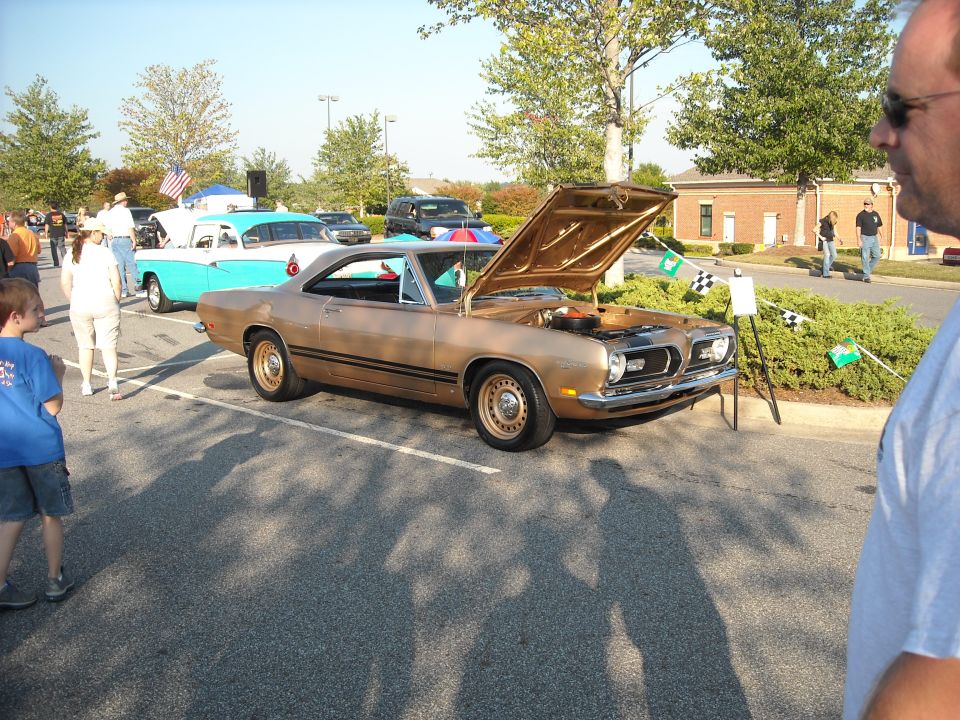 Gold 1968 Plymouth Barracuda with hood open at a car show