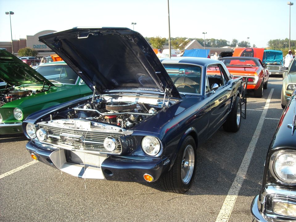 Dark blue Ford Mustang coupe with hood open at a car show