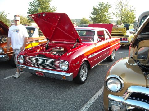 1979 Ford F-150 - A red 1963 Ford Falcon Sprint coupe is displayed with its hood open at a car show.