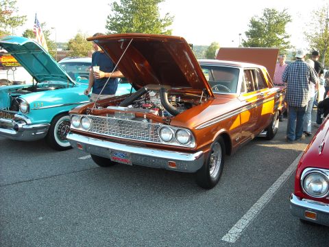 1979 Ford F-150 - Two classic cars, a 1963 Ford and a 1957 Chevy, displayed at an outdoor car show.