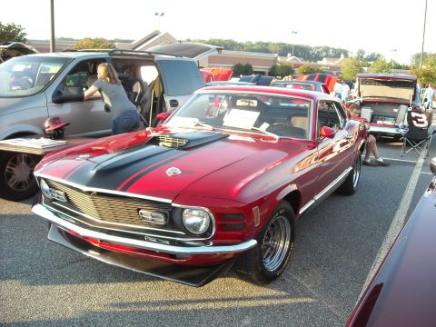 1979 Ford F-150 - A red 1970 Ford Mustang Mach 1 is parked at a car show.