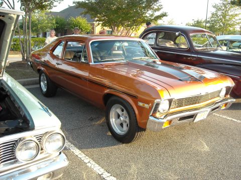 1979 Ford F-150 - A copper-colored 1970s Chevrolet Nova is parked at an outdoor event with other vehicles.