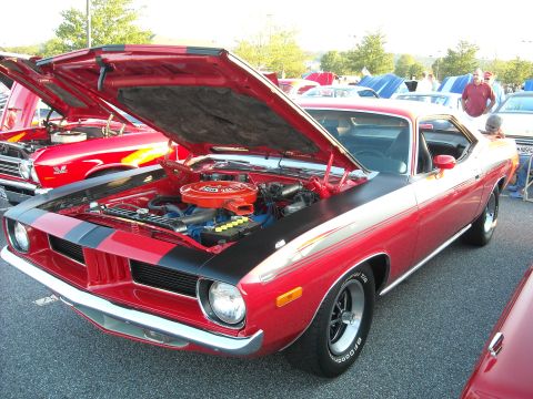 1979 Ford F-150 - Red 1970 Plymouth Barracuda at a car show, hood open to display the engine.