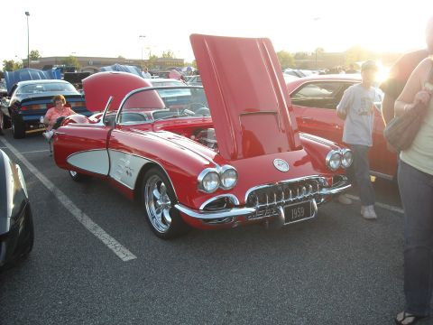 1979 Ford F-150 - A classic red 1959 Corvette is displayed with its hood open at an outdoor event.