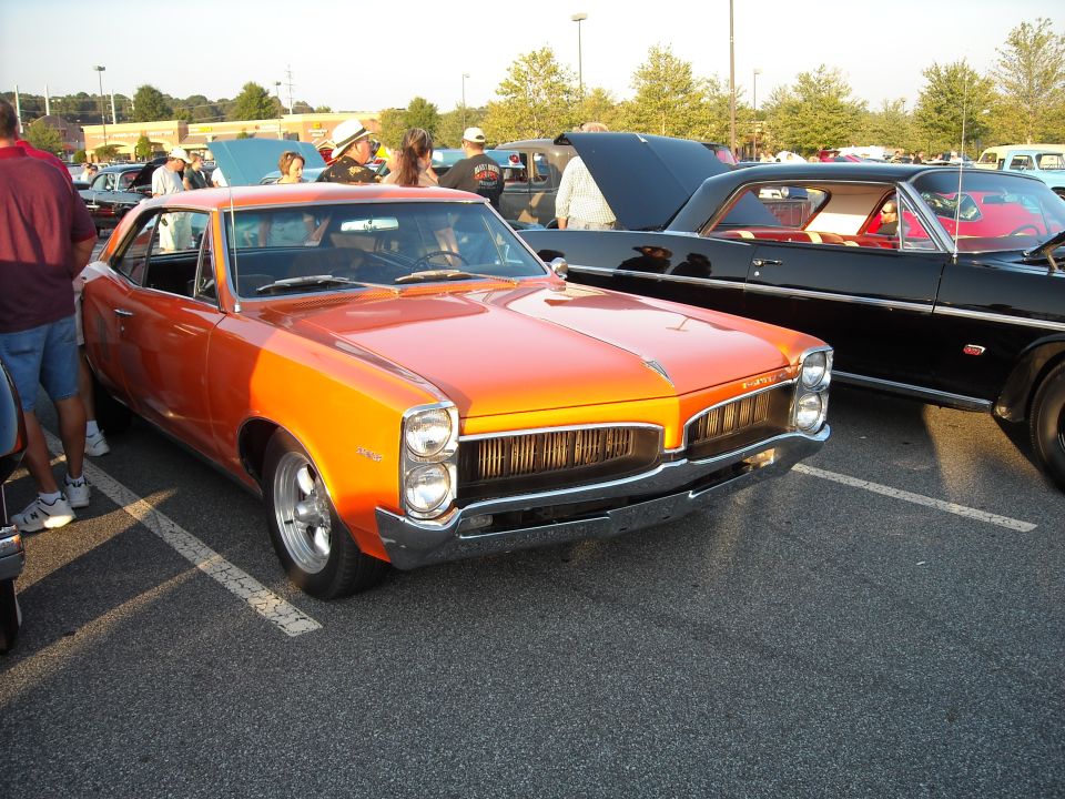 Orange 1966 Pontiac Tempest coupe parked at a car show, front quarter view