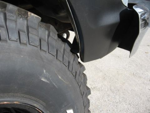 1978 Ford Bronco - A close-up view of a vehicle's tire and fender shows off-road tread and a black flare.