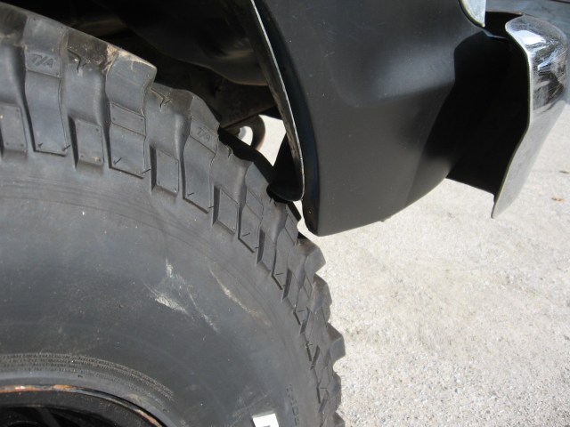 Close-up of a large off-road tire and part of a black fender flare on a vehicle