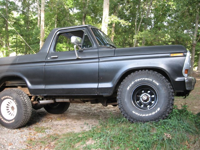 Black 1978 Ford Bronco with lifted suspension and off-road tires, viewed from the side