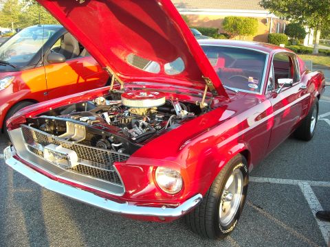 1979 Ford F-150 - Classic red Ford Mustang fastback at a car show, hood raised to display the engine.