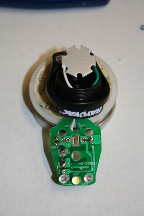 1984 Ford Bronco - A disassembled electronic component, possibly from a flashlight or similar device, is shown with its circuit board and LED.
