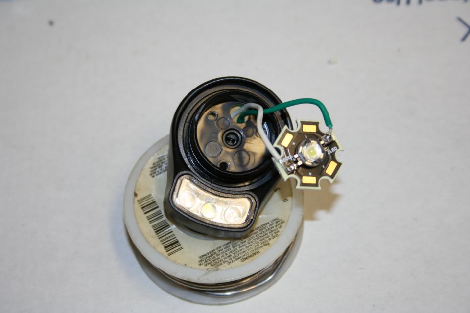LED light assembly with wires attached to a round black housing