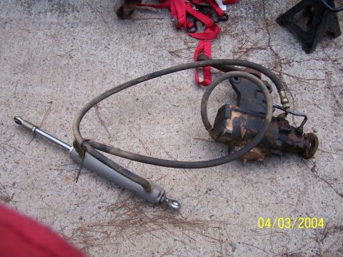 1979 Ford F-150 - A power steering gearbox and cylinder assembly is shown on a concrete surface, with a date stamp of 04/03/2004 visible.