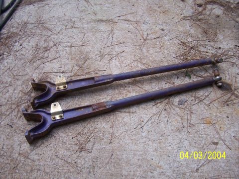 1979 Ford F-150 - Two purple metal rods with y-shaped ends and brass mounting plates are shown on a concrete surface.