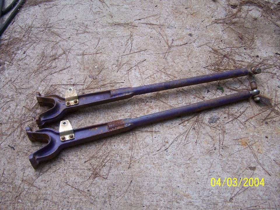 Pair of purple automotive radius arms or control arms on dirt floor