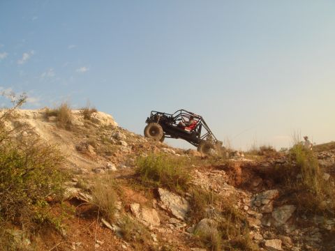 1992 Ford Bronco - A buggy navigates a challenging, rocky terrain under a clear blue sky.