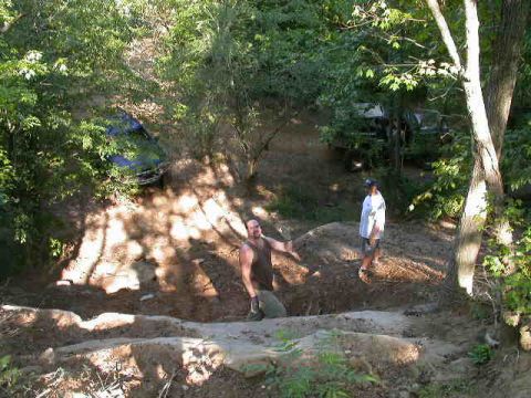 1990 Ford Bronco - Two people are on a dirt trail with two SUVs in the woods.