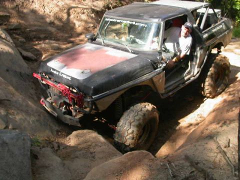1990 Ford Bronco - This vehicle is navigating a challenging off-road trail with steep, rocky inclines.