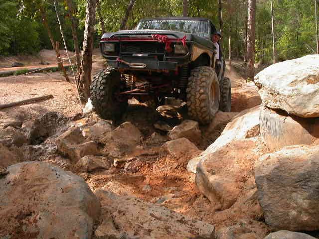 Black 1990 Ford Bronco climbing rocky terrain