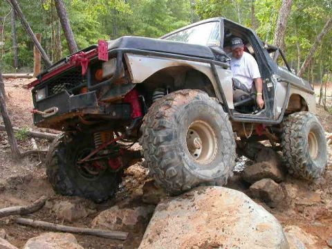 1990 Ford Bronco - This heavily modified off-road vehicle is shown tackling a challenging rocky trail.