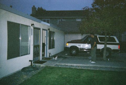 1991 Ford Bronco - A 1991 Ford Bronco is parked in a driveway next to a house, with a person standing nearby.