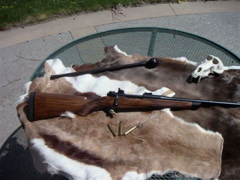 1991 Ford Bronco - A rifle, bullets, animal skull, and club are arranged on a fur rug on a table.