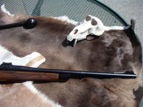 1991 Ford Bronco - A rifle and animal skull are displayed on a fur rug outdoors.