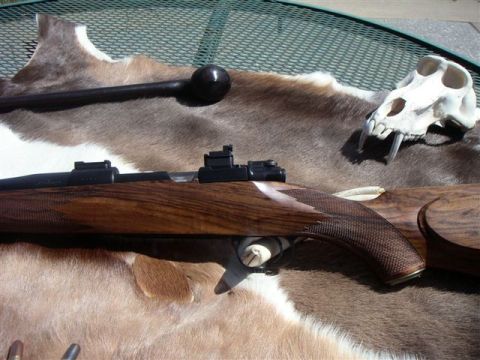 1991 Ford Bronco - A rifle's wooden stock and action are displayed on a fur rug next to a skull.