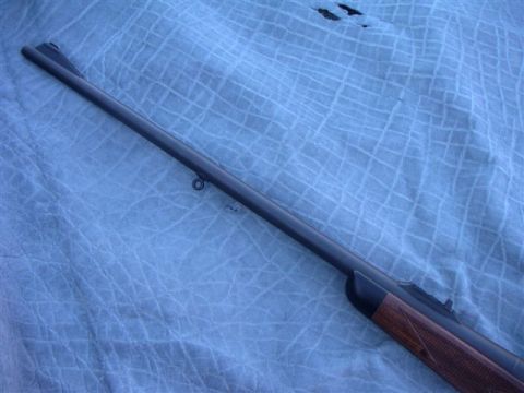 1991 Ford Bronco - Close-up view of a rifle's barrel and its checkered wooden stock.