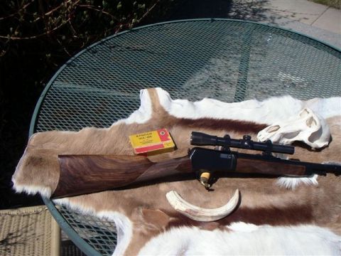 1991 Ford Bronco - A rifle, ammunition, and animal remains are arranged on a table covered with a fur rug.