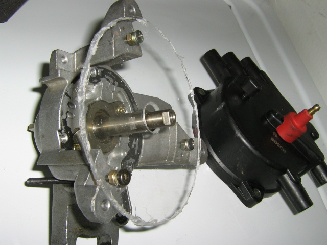 Distributor assembly with clear plastic cover removed, showing internal gears. Bosch ignition coil is attached