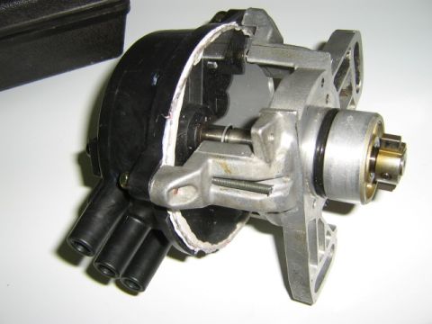 1995 Ford Probe - A disassembled automotive distributor is shown, revealing its internal mechanical parts and wire connectors.