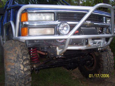 1978 Ford Bronco - Front view of a modified blue truck with a custom bumper and roll cage.